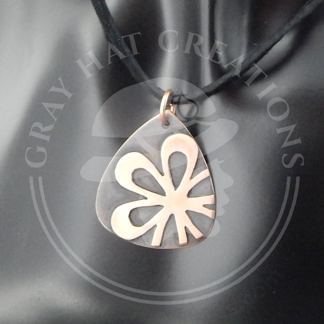 Flower shape on guitar pick background in copper antiqued pendant necklace